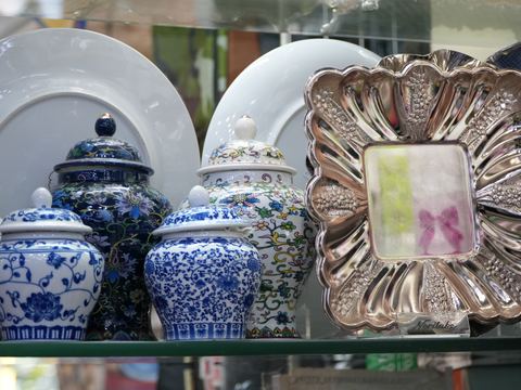 Blue and white ceramic ginger jars beside an ornate silver-toned platter.